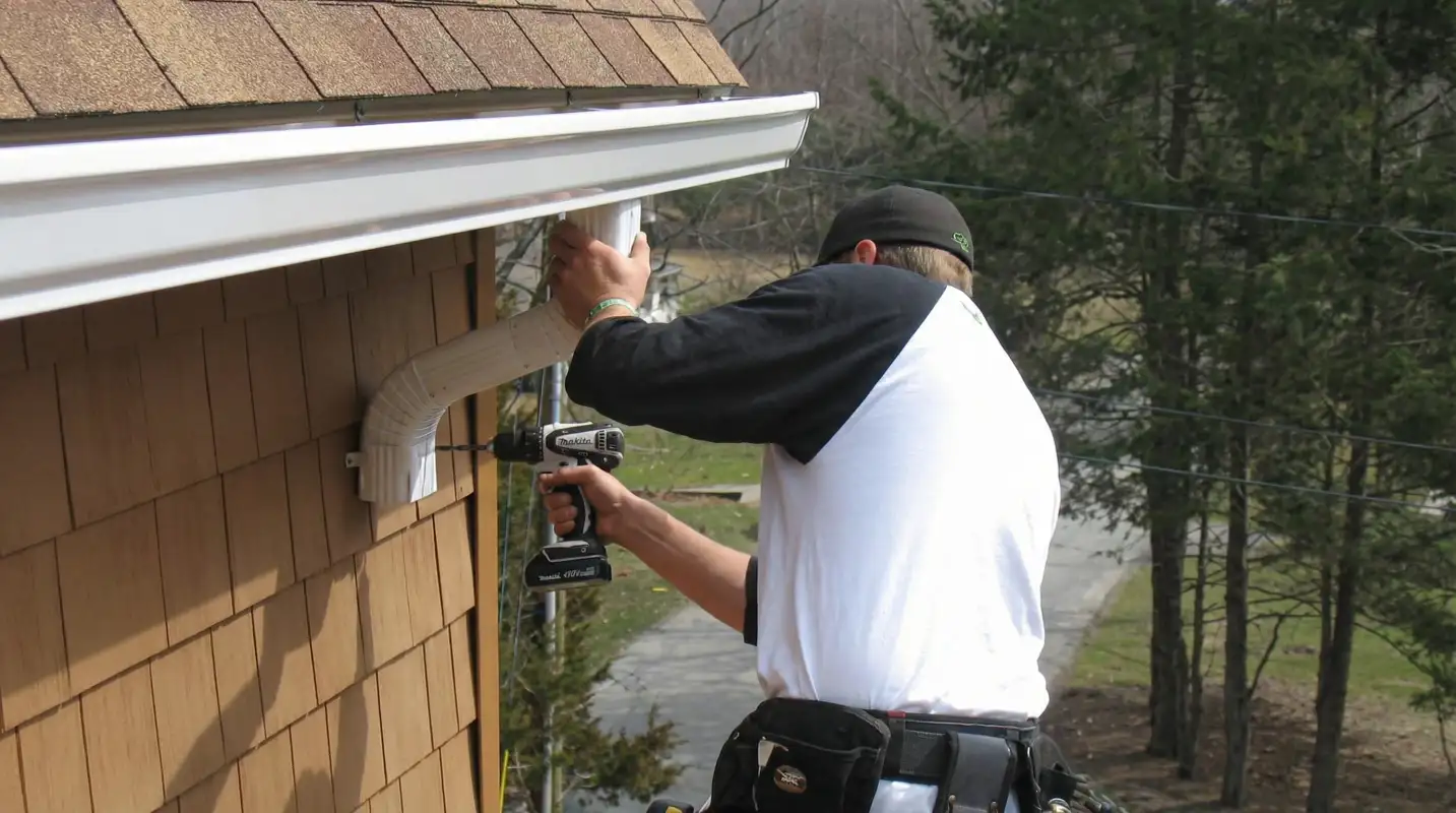 Professional contractor installing tan vinyl siding panels on a residential home exterior in Irvine, CA